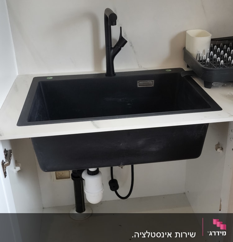 כיור שחור עם ברז, צנרת מתחת לכיור